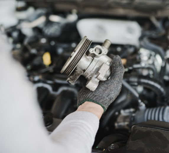 Hand of car mechanic with spare parts at service center repair